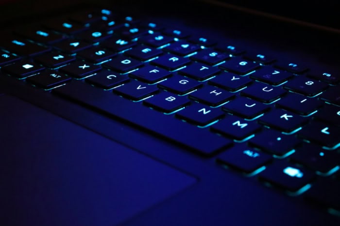 Close up of a laptop keyboard with blue backlight