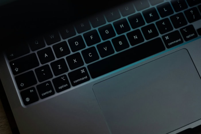 Close up of a laptop keyboard with dim lighting