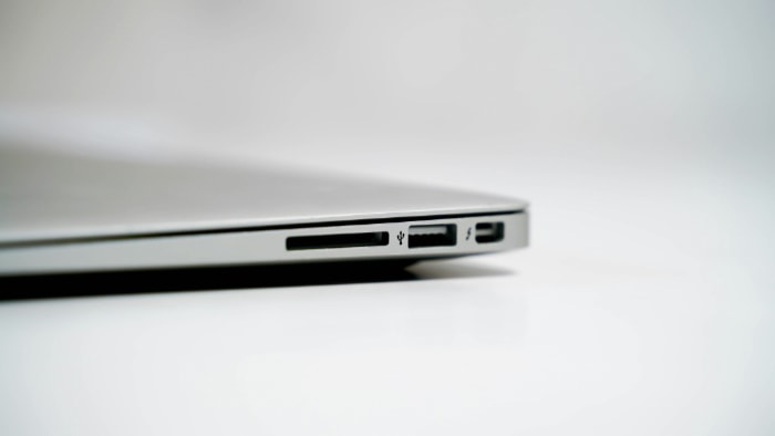 Close up of a laptops side with a black USB port and SD card slot