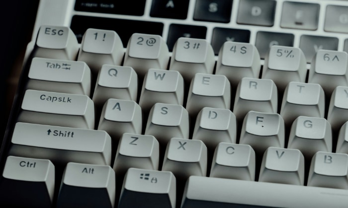 Close up of a mechanical keyboard with white keycaps and dark lettering