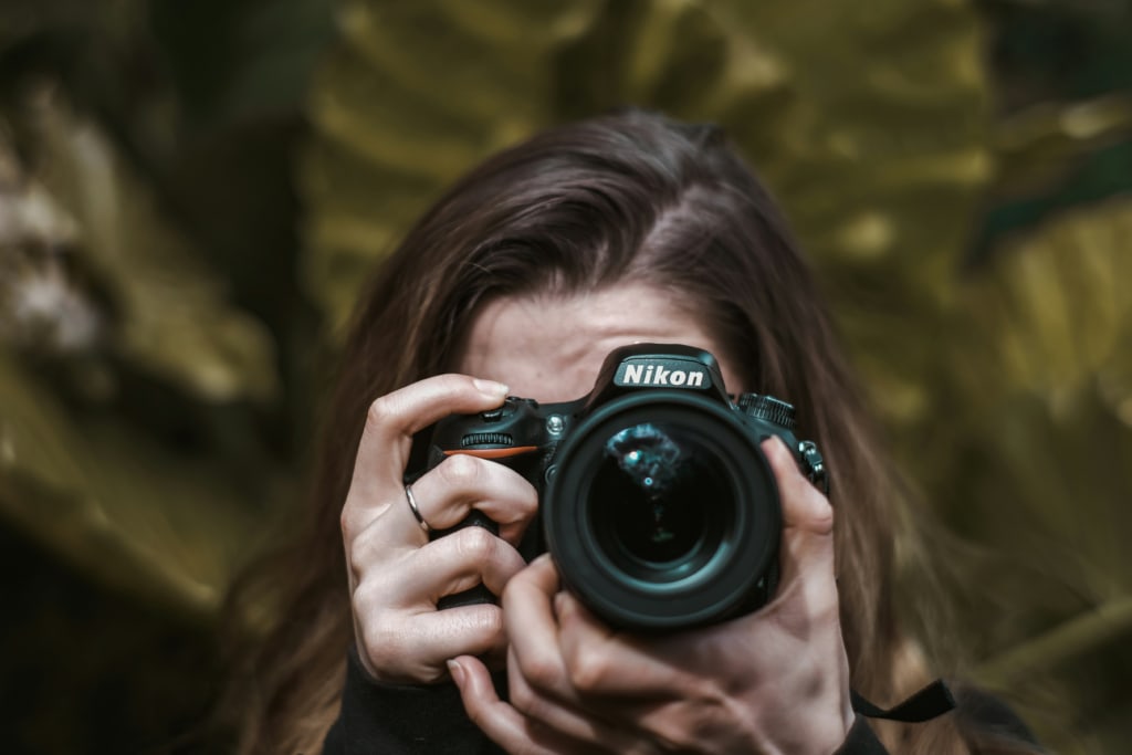 Close up of a photographer focusing a Nikon camera lens