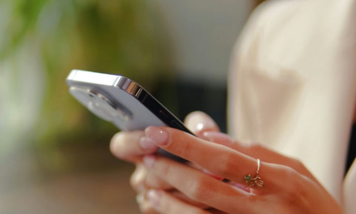 Close up of a womans hands holding an iphone with a blurred background