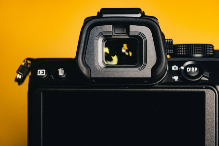 Close up of digital camera viewfinder against yellow background