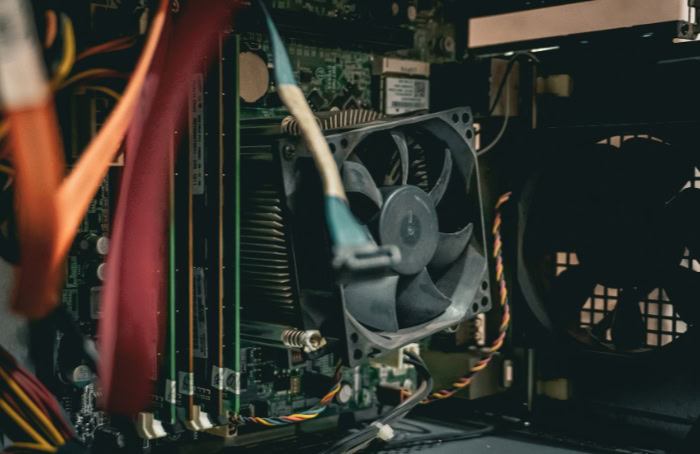 Close up of dusty computer fan and cables inside PC