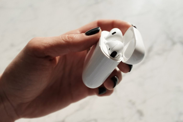 Close up of hand holding open AirPods charging case