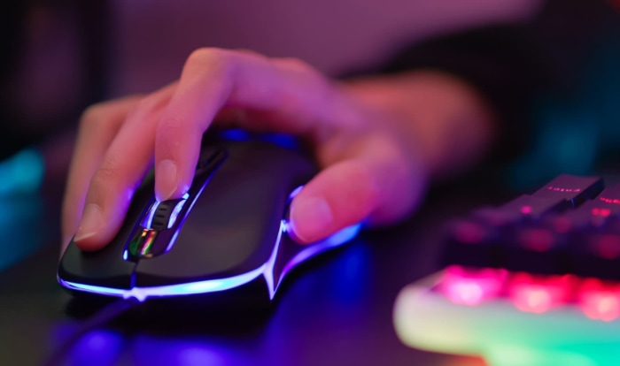 Close up of hand play game with RGB keyboard and mouse