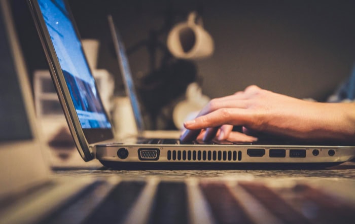 Close up of hand typing on laptop keyboard with blurred background