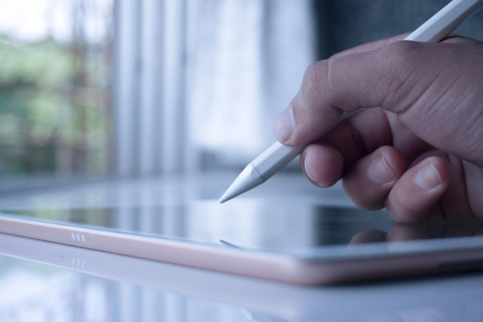 Close up of hand using stylus on tablet screen