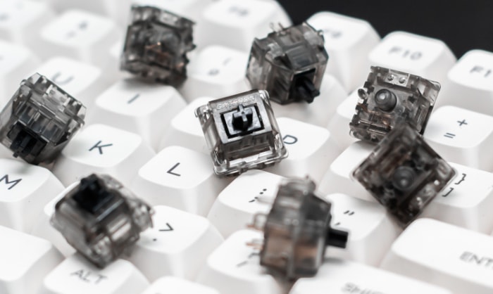 Close up of mechanical keyboard switches scattered on white keys