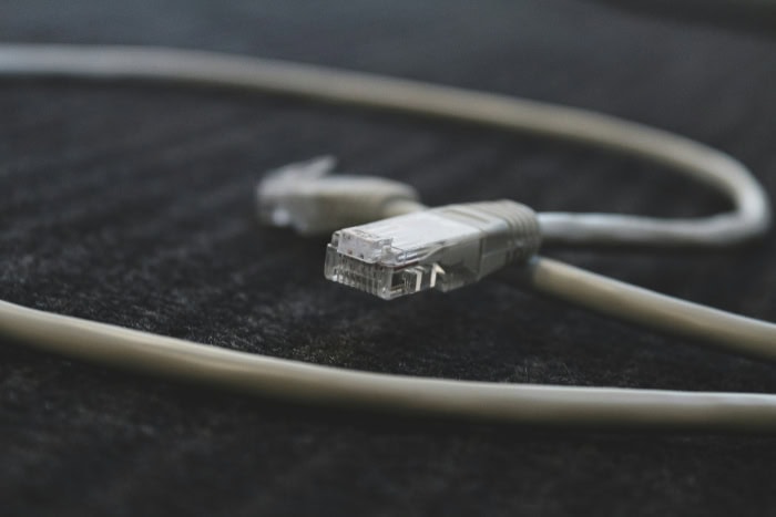 Close up of white ethernet cable connector on dark surface