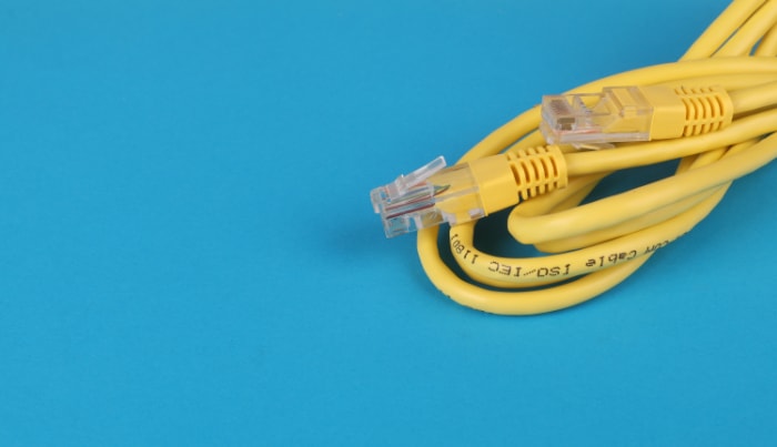 Close up of yellow ethernet cable on blue surface