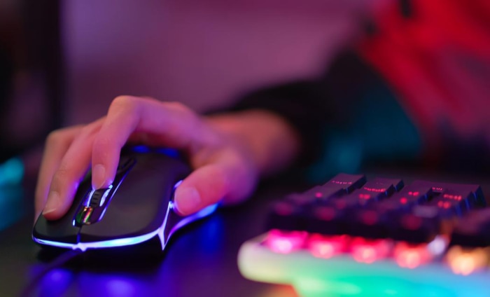 Close up person using mouse and rgb keyboard