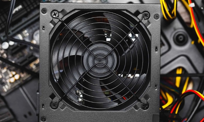 Close up view of a PC power supply fan set against internal components