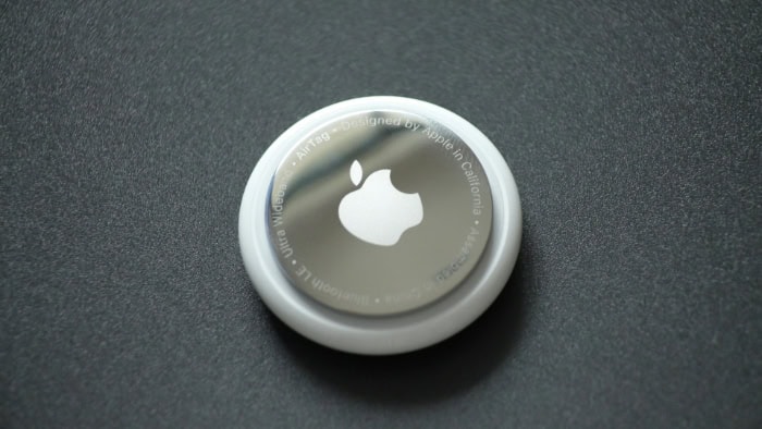 Close up view of an Apple AirTag on a dark surface