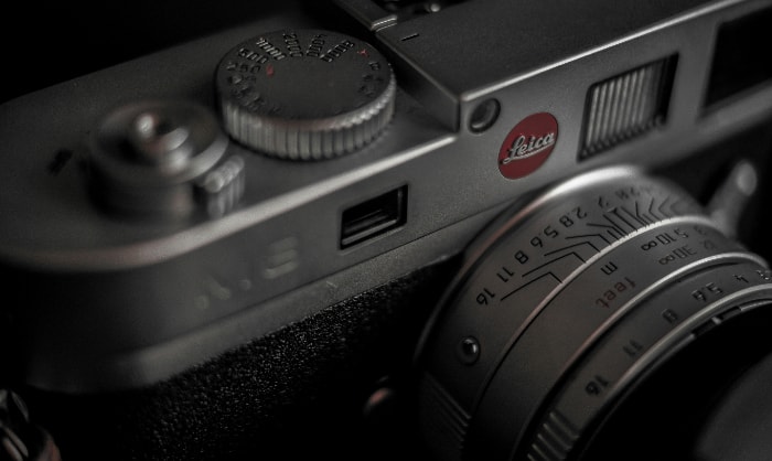Close view of Leica camera dials next to the iconic red logo