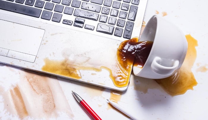 Coffee spilled across a laptop keyboard and workspace