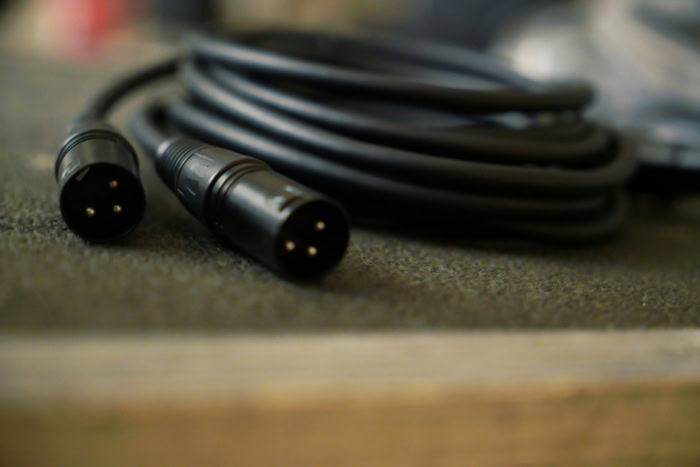 Coiled black XLR microphone cable on a surface