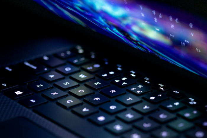 Compact laptop keyboard illuminated with colorful light streaks
