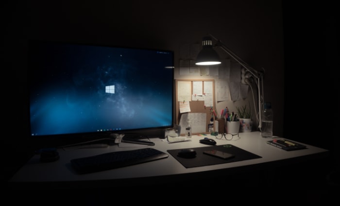 Computer and desk lamp turned on