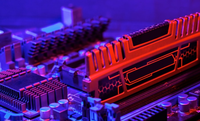 Computer motherboard with orange RAM under blue lighting