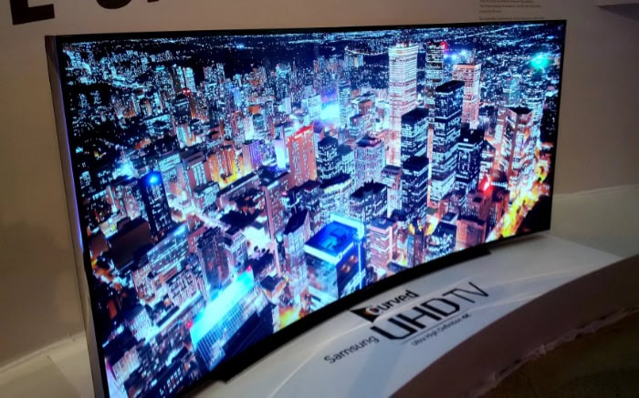 Curved Samsung UHD TV displaying a vibrant cityscape