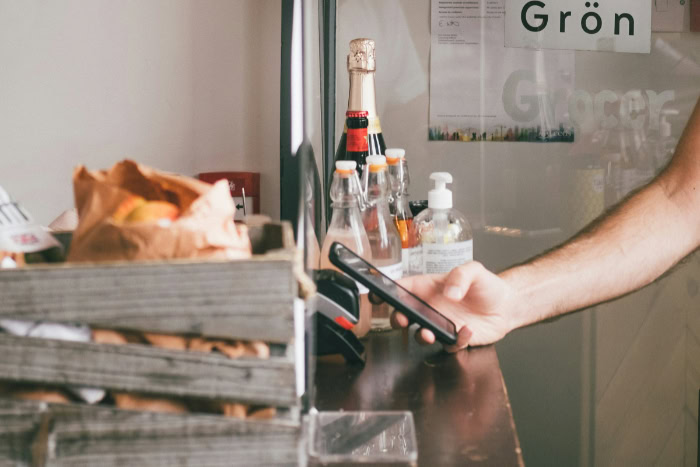 Customer paying with Apple Pay at a grocery checkout counter