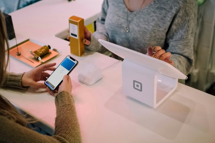 Customer using Apple Pay at a modern checkout counter