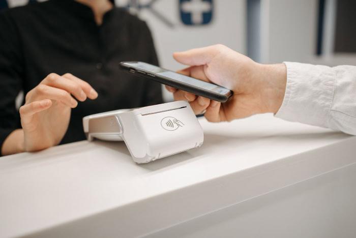 Customer using smartphone for contactless payment at checkout