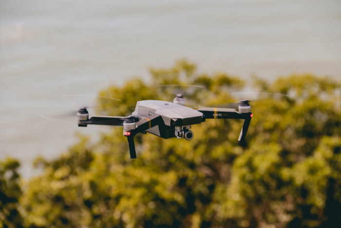 DJI Mavic Pro drone flying above green trees