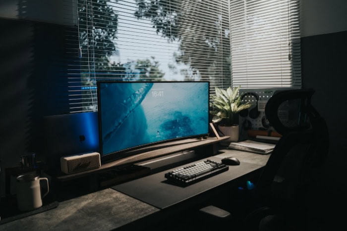 Dark workspace setup with curved monitor