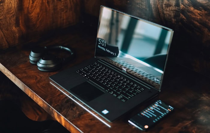 Dell XPS laptop and smartphone on wooden table