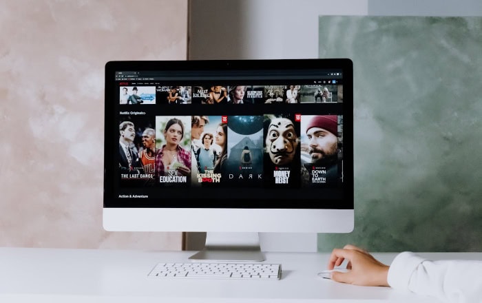 Desktop computer displaying Netflix homepage with movie thumbnails