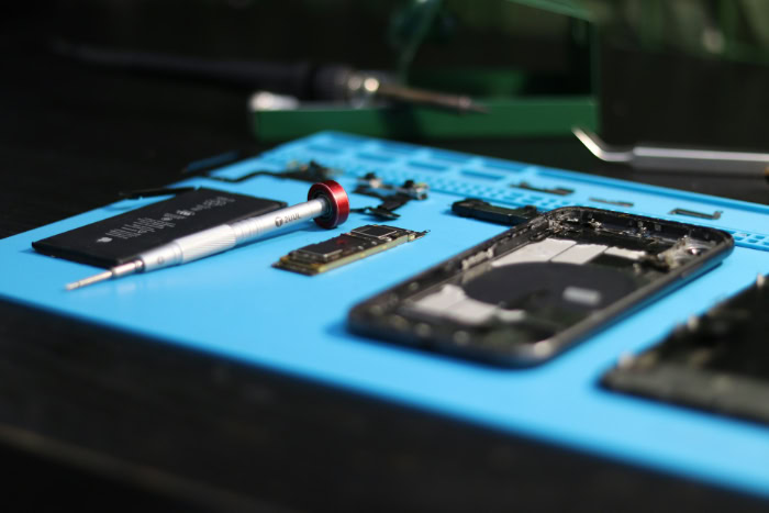 Disassembled phone parts on blue repair mat resized