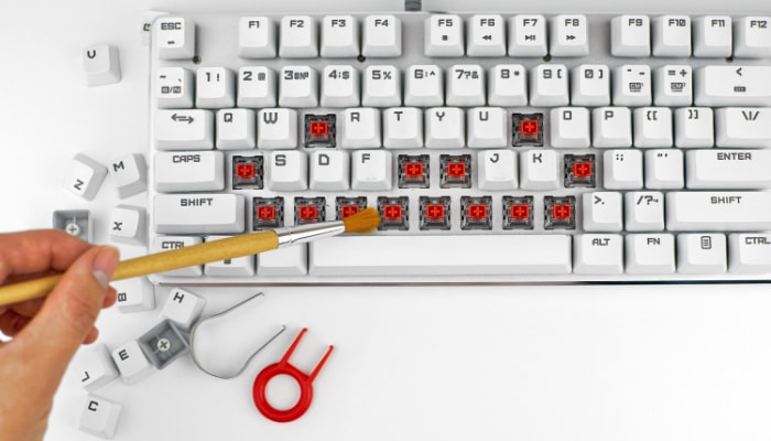 Disassembled white mechanical keyboard with tools
