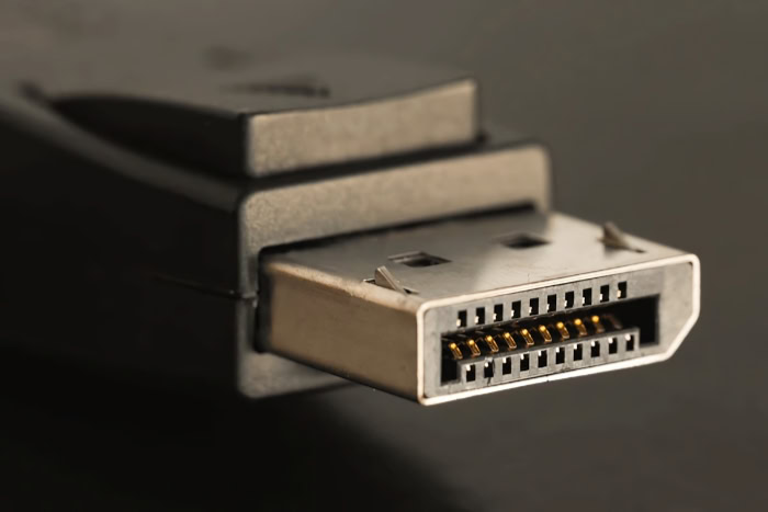 DisplayPort cable connector with gold pins on dark background