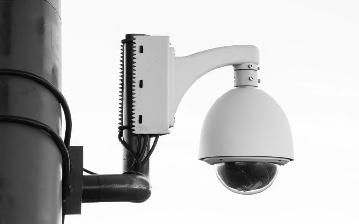 Dome security camera mounted on white pole