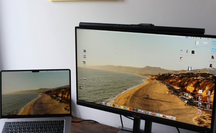 Dual monitor setup showing coastal landscape desktop background