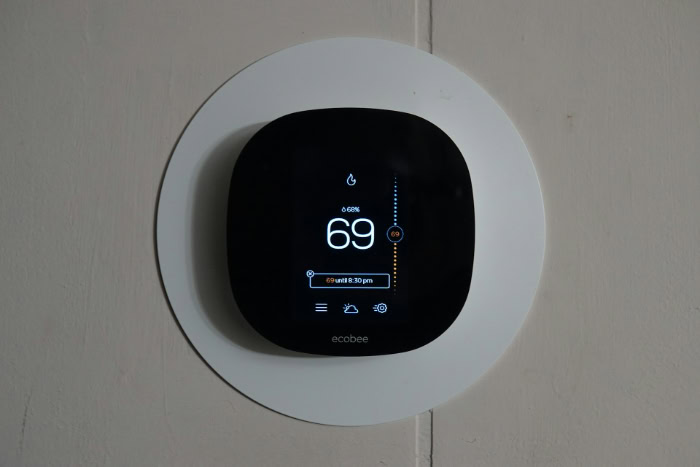 Ecobee smart thermostat mounted on a circular wall plate