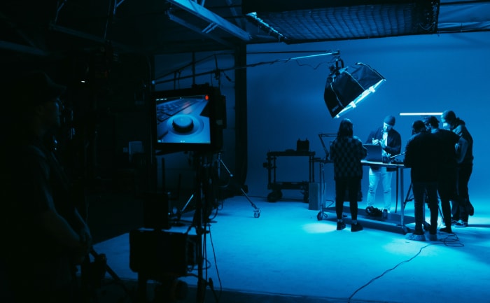Film crew working on a set with blue lighting