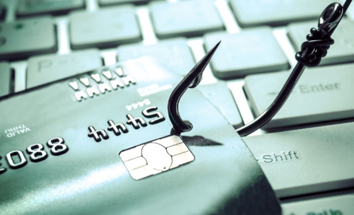 Fish hook resting on a credit card placed over a keyboard