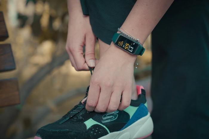 Fitness tracker smartwatch worn with colorful athletic shoe