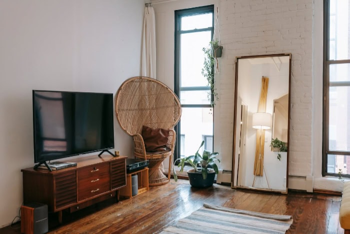 Flat TV on wooden stand in bright living room