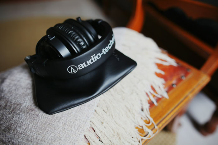 Folded black Audio Technica headphones resting on carrying pouch