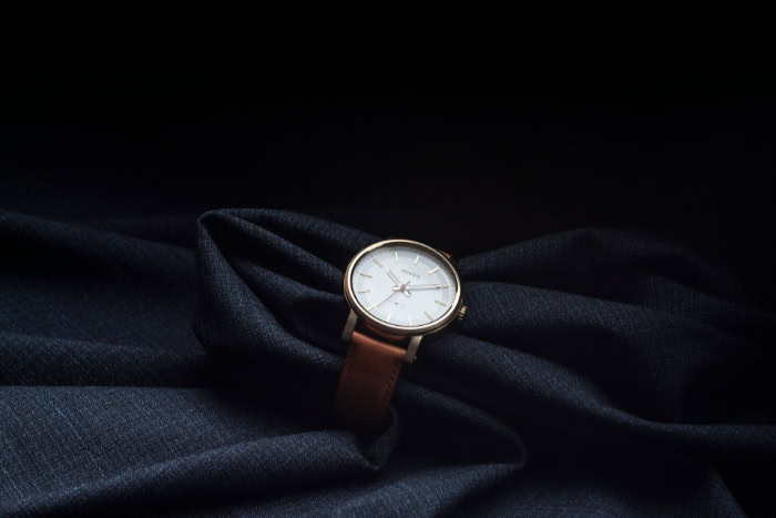 Fossil watch with brown leather strap on blue fabric