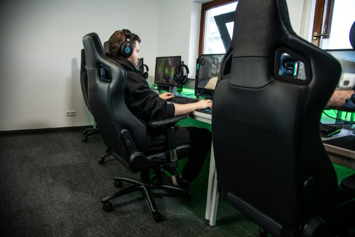 Gamer seated in a black gaming chair at a desk