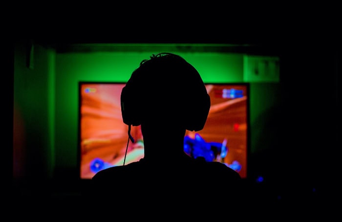 Gamer silhouette playing video game with headset