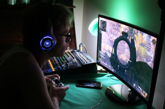 Gamer wearing headphones playing on a monitor