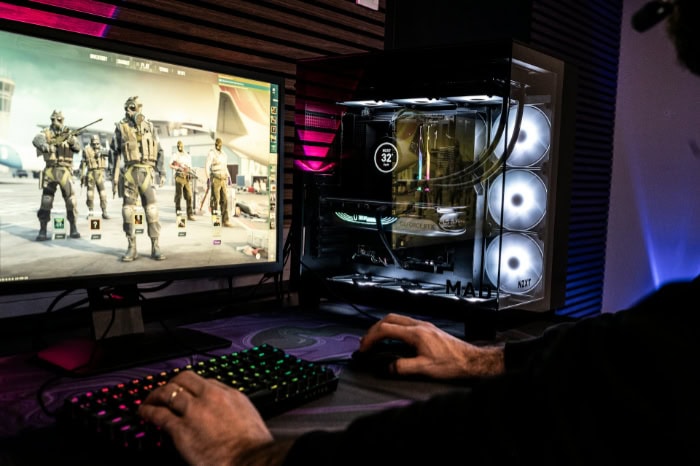 Gaming PC with transparent case and FPS game on monitor