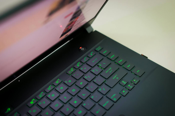 Gaming laptop keyboard with green backlighting and screen