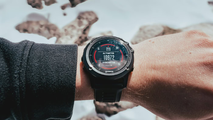 Garmin Fenix smartwatch on wrist in snowy landscape